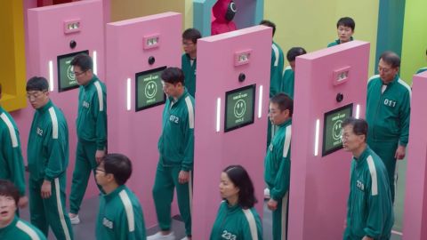 Des hommes et femmes coréens habillés en vert passent au travers de portiques rose