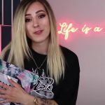 Une jeune fille blonde face tient un colis de la marque Shein