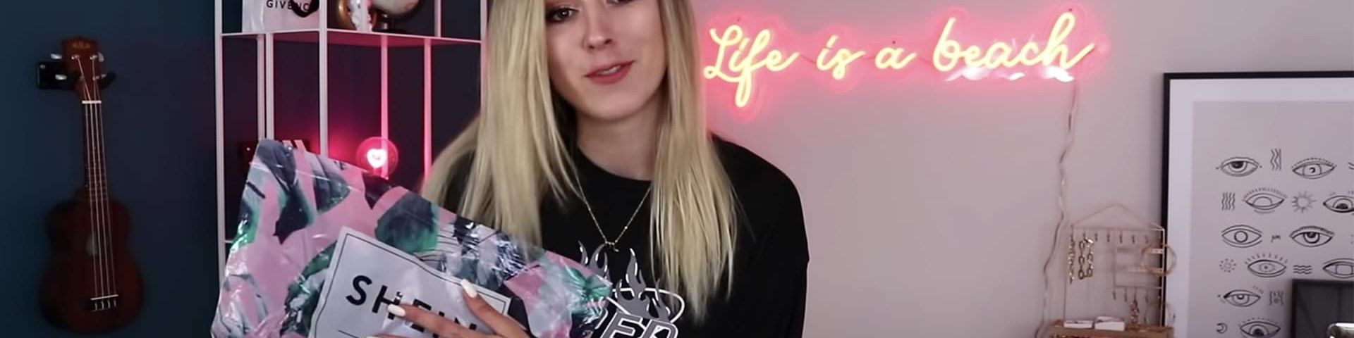 Une jeune fille blonde face tient un colis de la marque Shein