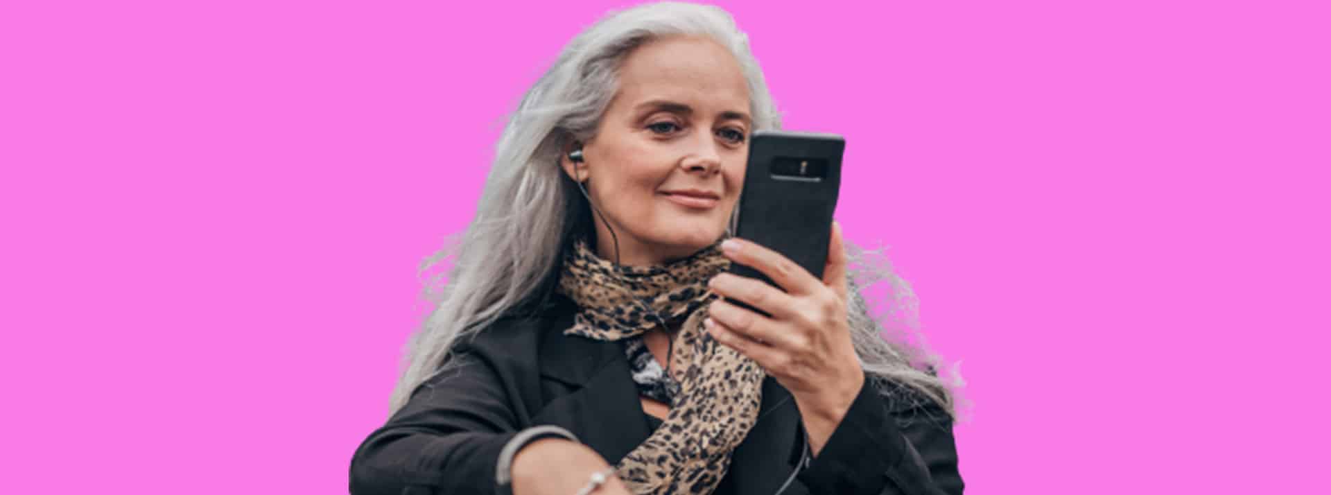 South-agency - L'ADN Une femme d'une cinquantaine d'années regarde son smartphone dans la rue