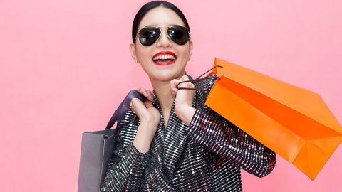 Une femme souriante et chic en train de faire du shopping