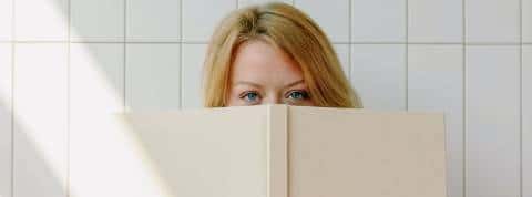 Quels sont les livres tech à lire ? Une femme en train de lire un grand livre