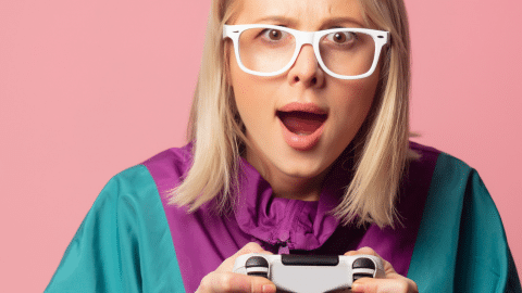 Une fille blonde tient une manette de console
