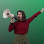 Jeune femme bras en l'air criant dans un mégaphone