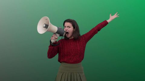 Jeune femme bras en l'air criant dans un mégaphone