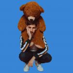 Portrait de Ben Névert avec un nounours sur les épaules