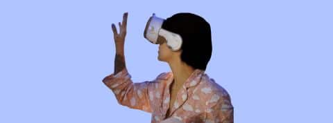 La Corée lance un alliance du métavers Jeune femme en pyjama rose sur fond bleu avec casque de réalité virtuelle sur la tête