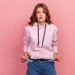 Jeune fille en jean qui tire ses poches vides en faisant la moue