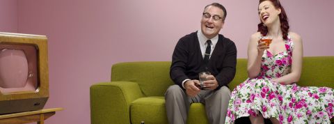 Sturti Couple années 50, riant en prenant l'apéro sur un canapé