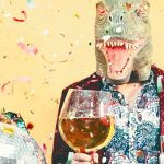 Deux personnes en train de faire la fête, avec sur la tête un masque de lézard et un de coq