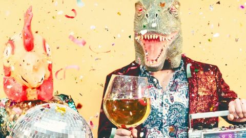 Deux personnes en train de faire la fête, avec sur la tête un masque de lézard et un de coq