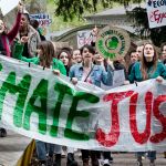 Des manifestants tiennent une banderole "Climate justice"