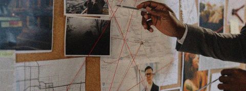 Enquête, investigation Main avec stylo désignant une photo sur un mur de documents dans le cadre d'une enquête