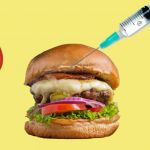 Sur fond jaune, deux tranches de tomate et un burger dans lequel se plante une seringue