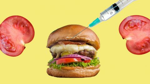 Sur fond jaune, deux tranches de tomate et un burger dans lequel se plante une seringue