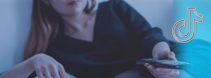 Femme allongée avec télécommande dans la main et logo TikTok