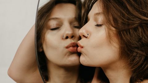 Une femme embrasse un miroir