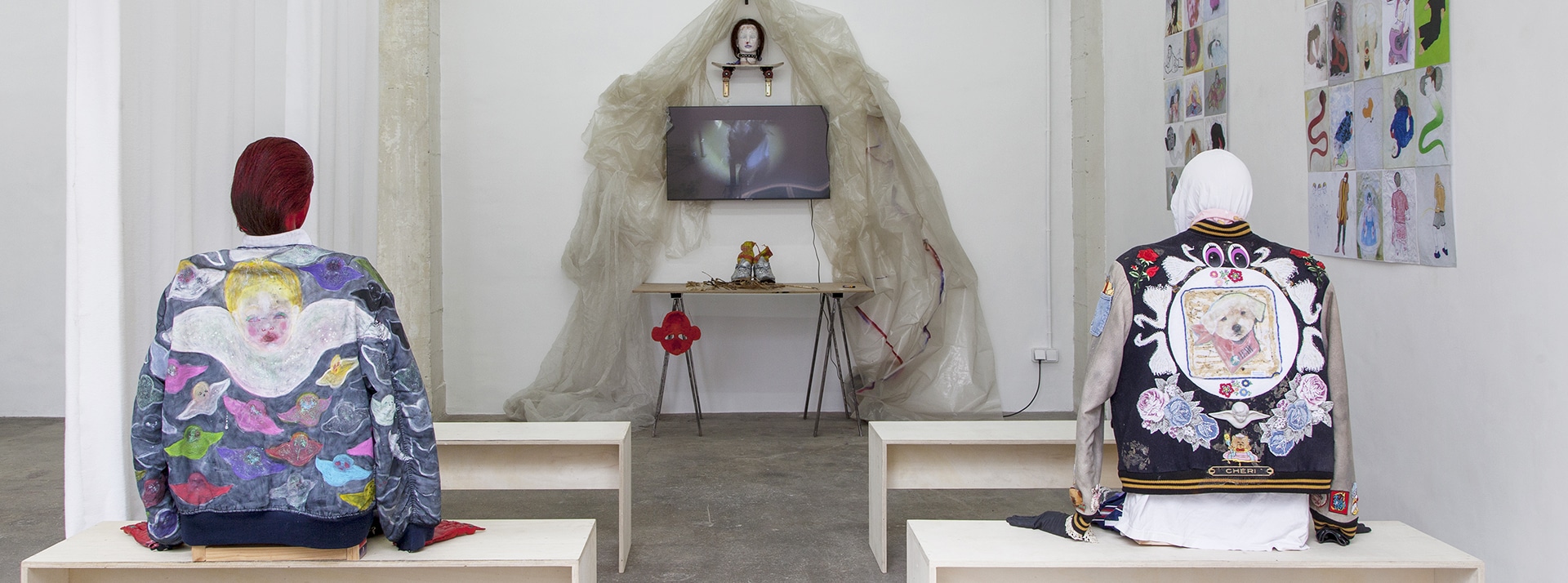 Installation d'art contemporain avec mannequins de dos aux blousons bariolés