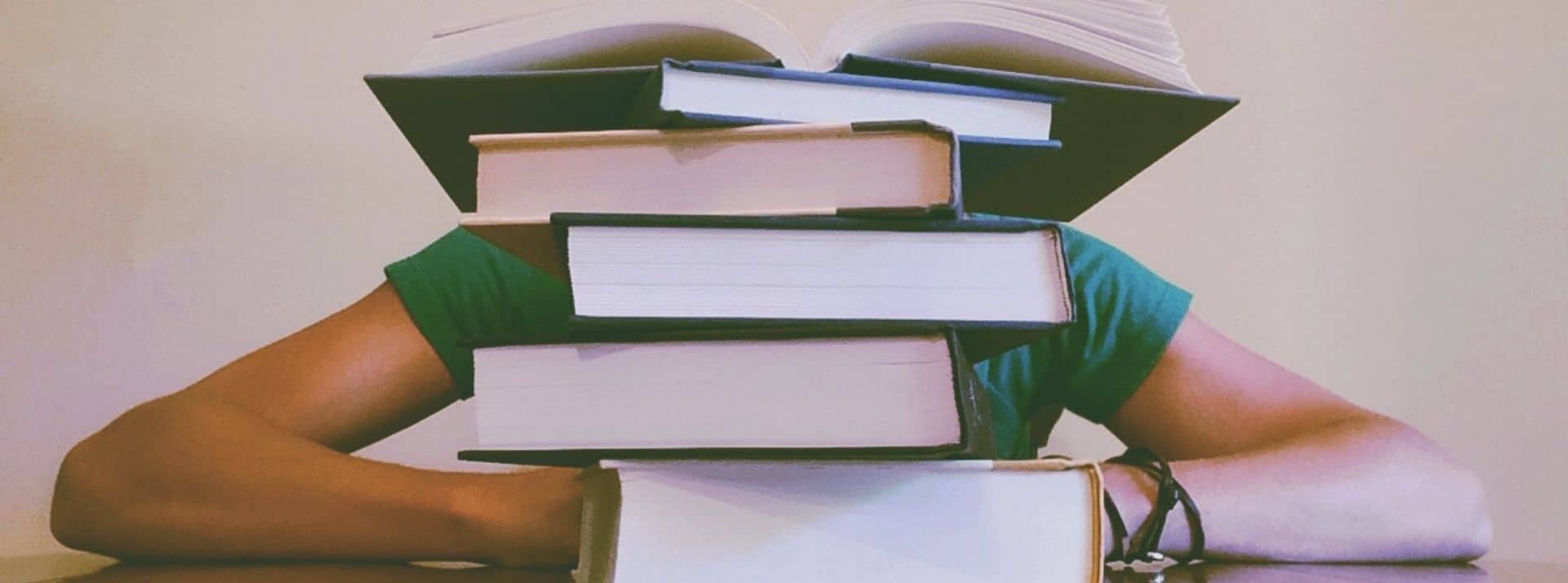 Good books : 5 essais tech de 2021 à lire Un homme sous une pile de livre