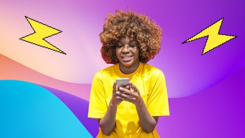 Jeune femme métisse en T-shirt jaune regardant son smartphone