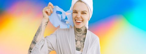 Beauté, make-up, tatouage Jeune femme tatouée enlevant son masque beauté en souriant