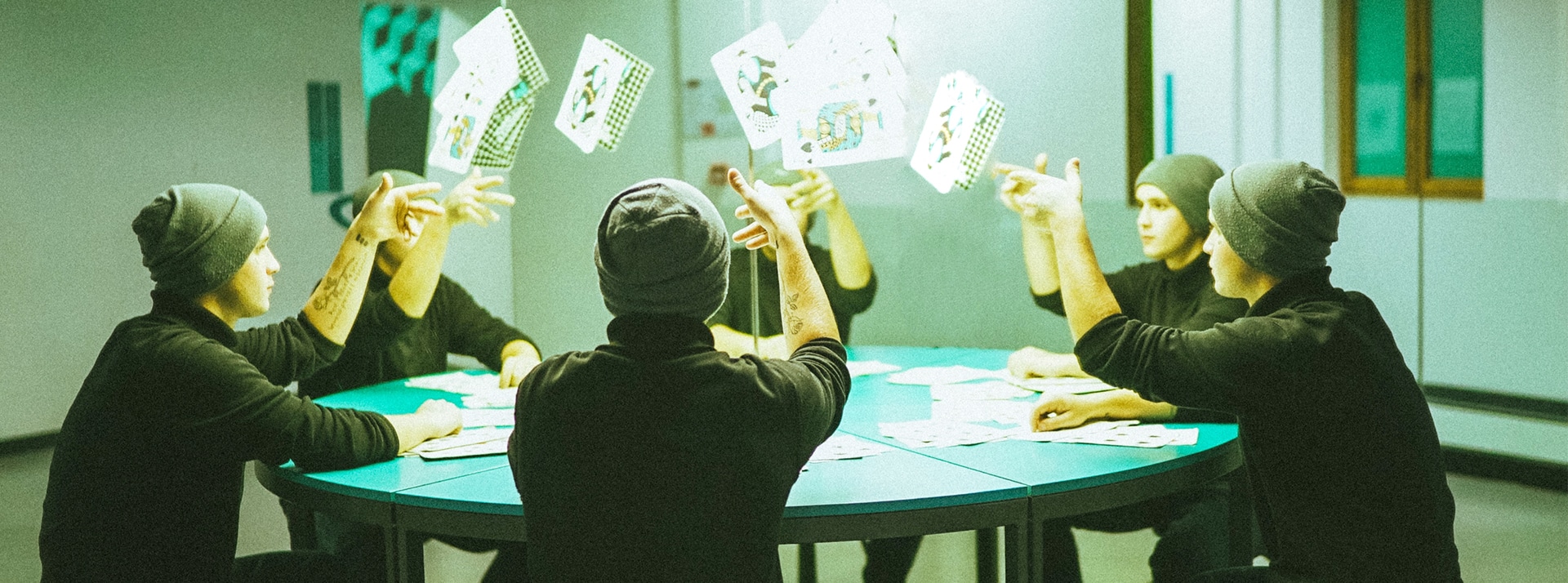 Un groupe d'hommes identiques à une table de poker jettent leurs cartes en l'air