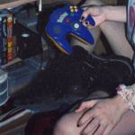 mains d'une jeune fille avec chouchou au poignet et vieille console de jeu