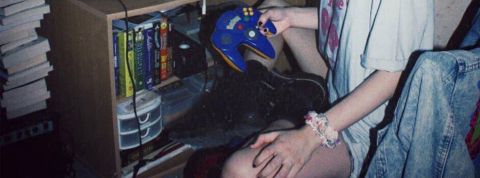 C'est quoi la newstalgia ? mains d'une jeune fille avec chouchou au poignet et vieille console de jeu