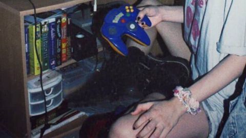 C'est quoi la newstalgia ? mains d'une jeune fille avec chouchou au poignet et vieille console de jeu