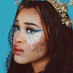 Une femme brune avec une couronne dorée sur fond bleu