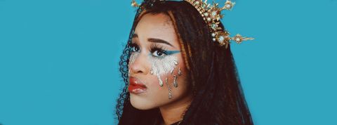 Bonjour le God complex Une femme brune avec une couronne dorée sur fond bleu