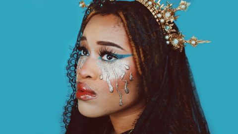 Bonjour le God complex Une femme brune avec une couronne dorée sur fond bleu