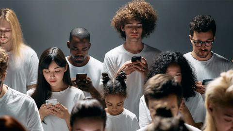 Sur fond gris, plein d'hommes et de femmes en train de regarder leur téléphone