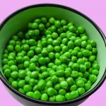 Bol de pois verts sur fond rose
