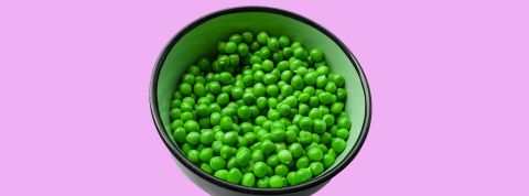 légumineuses, protéines Bol de pois verts sur fond rose