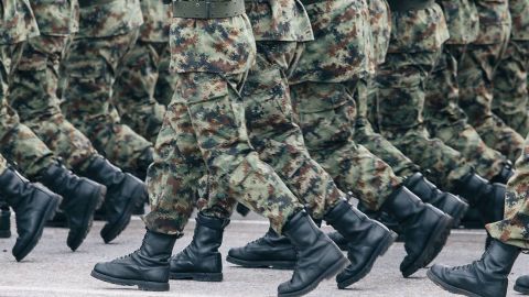 Vue sur des lignes de jambes de militaires en uniforme camouflage