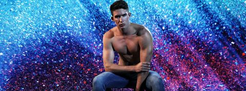 Beau jeune homme en jean torse nu sur fond de paillettes