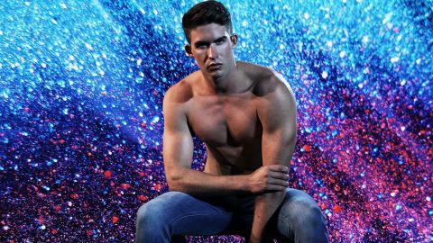 Beau jeune homme en jean torse nu sur fond de paillettes