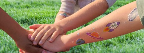 école du climat bras d'enfants avec tatouages planètes