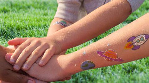 bras d'enfants avec tatouages planètes
