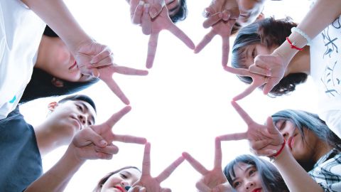 8 personnes forment une étoile avec leur doigt