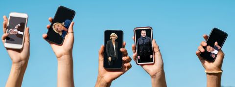 Pourquoi confier nos opinions politiques à des applis n'est pas une bonne idée Des personnes brandissent leur smartphone avec des photos de politiques en fond d'écran