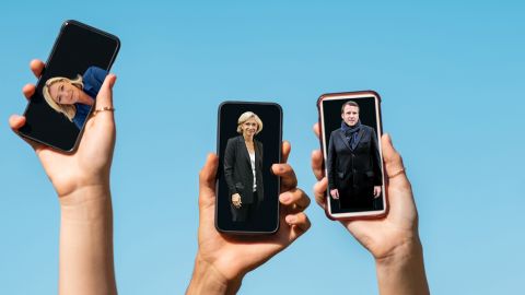 Des personnes brandissent leur smartphone avec des photos de politiques en fond d'écran