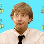 Un homme en chemise blanche et cravate noire fait la grimace devant un fond bleu