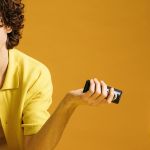 Jeune homme avec sa télécommande et TV, dans les tons jaunes