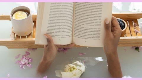 Bain relaxant avec livre, tisane et fleurs