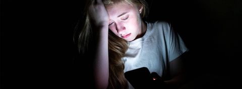 Moore-Media-Getty une jeune fille en pleur devant son portable dans le noir