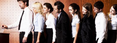 Employés formant une ligne etttendant pour mettre leur bulletin dans l'urne