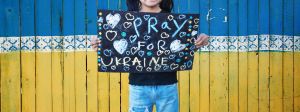 Enfant tenant pancarte Pray for Ukraine