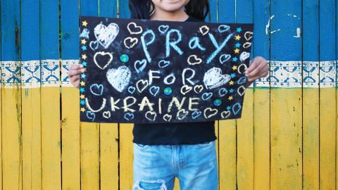Enfant tenant pancarte Pray for Ukraine